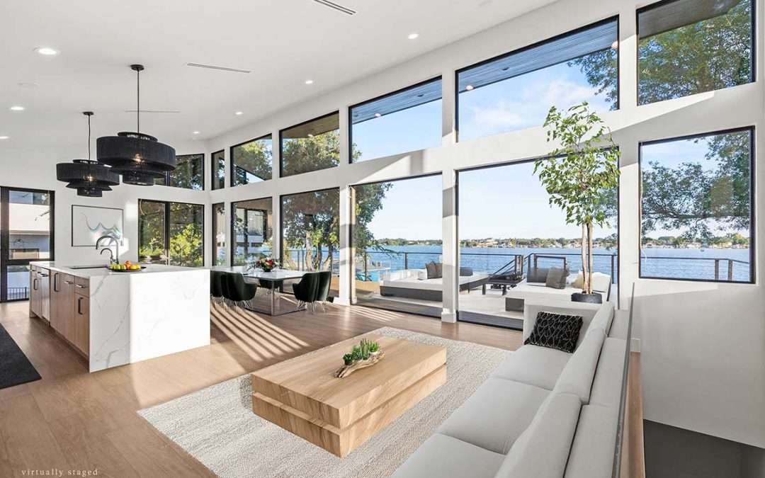 Texas Home Builders open-concept living area with full-height windows, lake views, modern kitchen, and indoor–outdoor design.